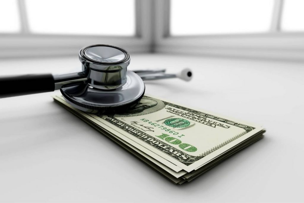 Stethoscope and cash for financial health checkup