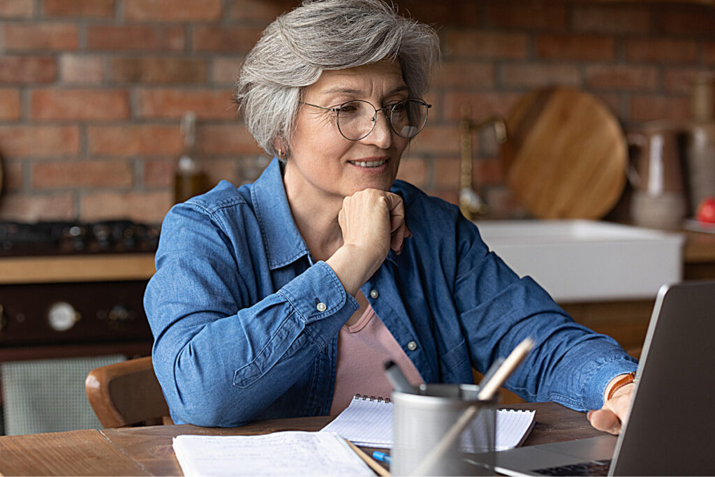 Older woman working on laptop to make extra money